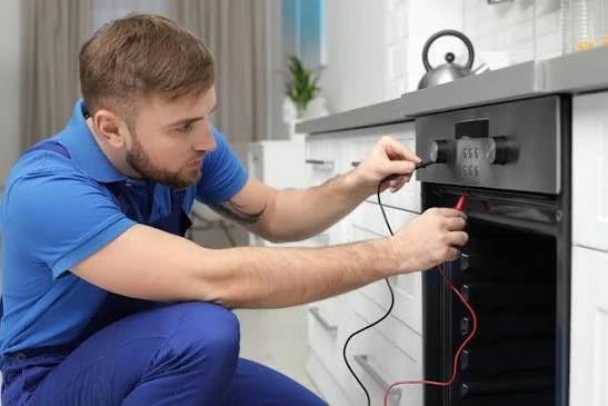 Technician testing an oven and its control panel